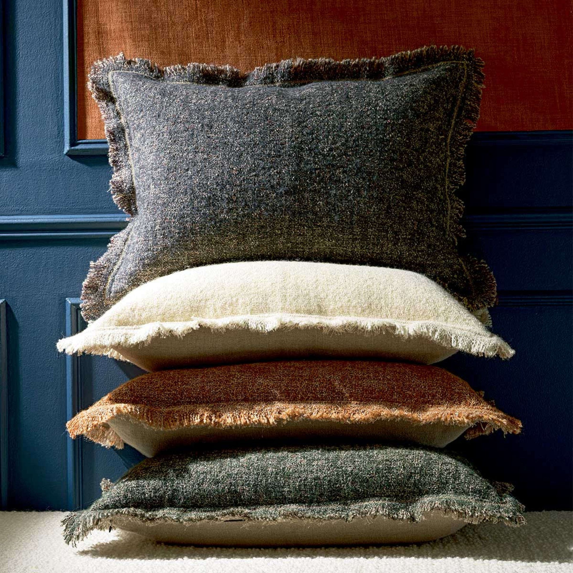 stack of four mottled wool Balzac cushions from Elitis in a variety of plain colours