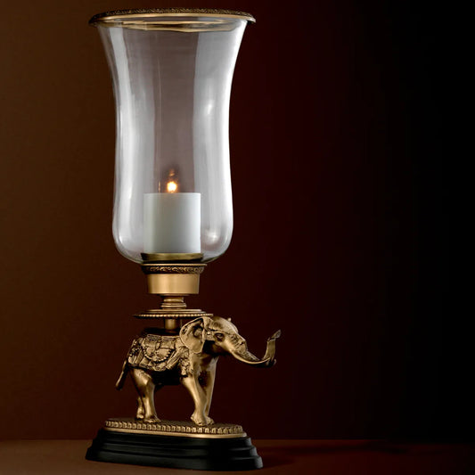 Eichholtz Elephant Hurricane lamp with an asian elephant on a black granite base supporting a brass trimmed clear glass vase