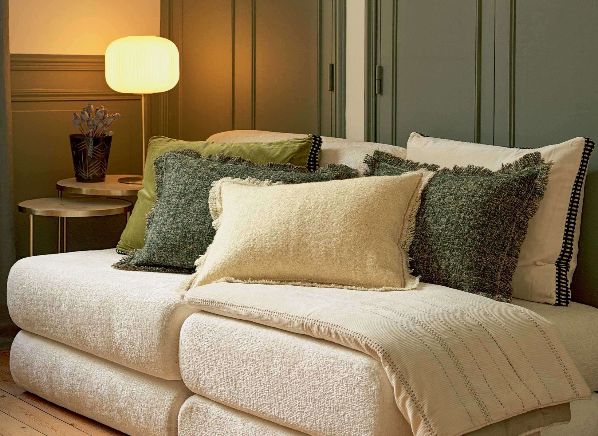 Elitis cushions spread across a white couch including the Balzac and the Athena cushions