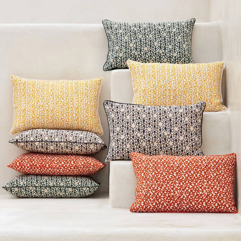 A group of Azteca cushions by Elitis with tiny tile motiffs in yellow, rugs, green and black