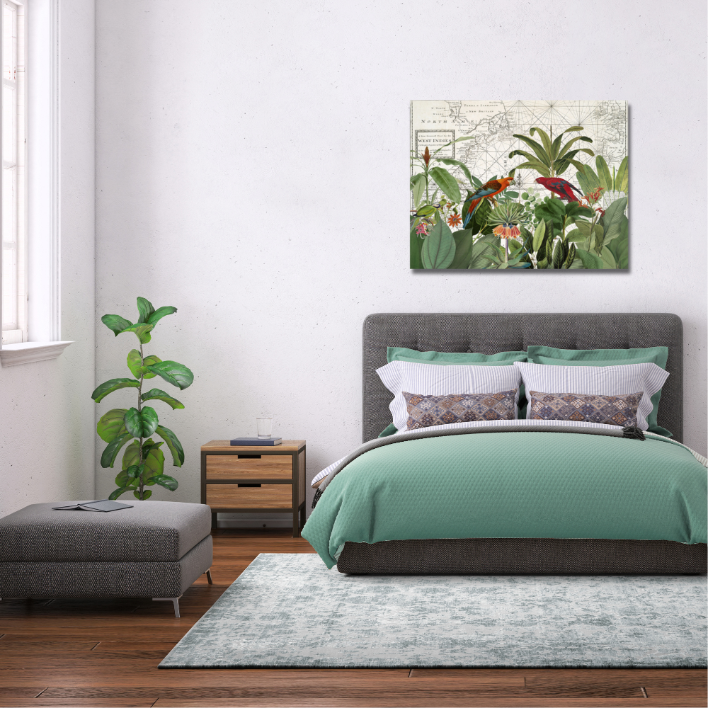 tropical bird canvas in a vintage style above a grey and green bed. Green foliage in the corner of a white room with a window and a grey ottoman underneath the window. The bed is seated on a grey and white marle rug
