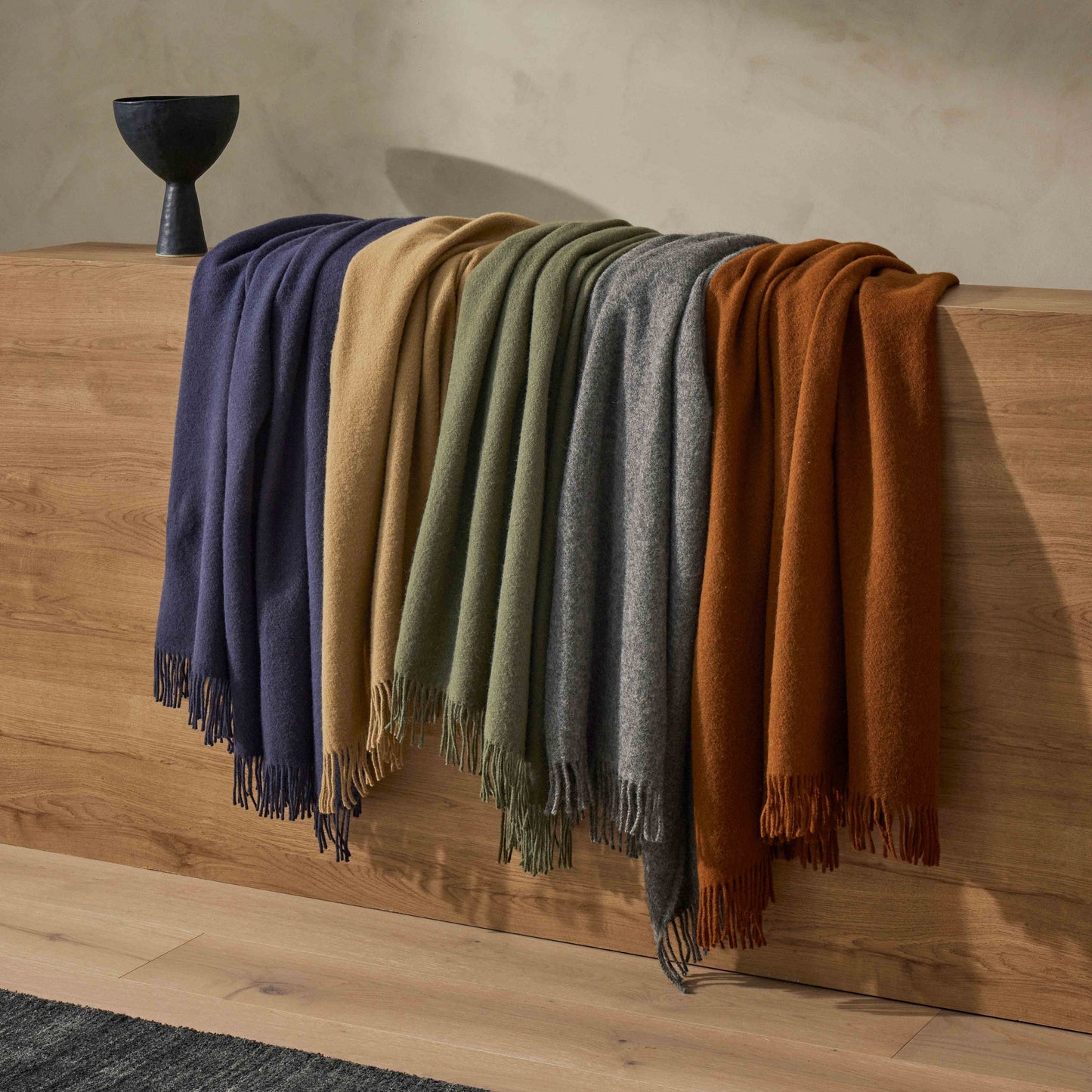 Nevis wool throws draped over a wooden table