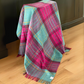 Saltburn New Zealand Wool Throw in Cerise and Aqua check draped over a stool