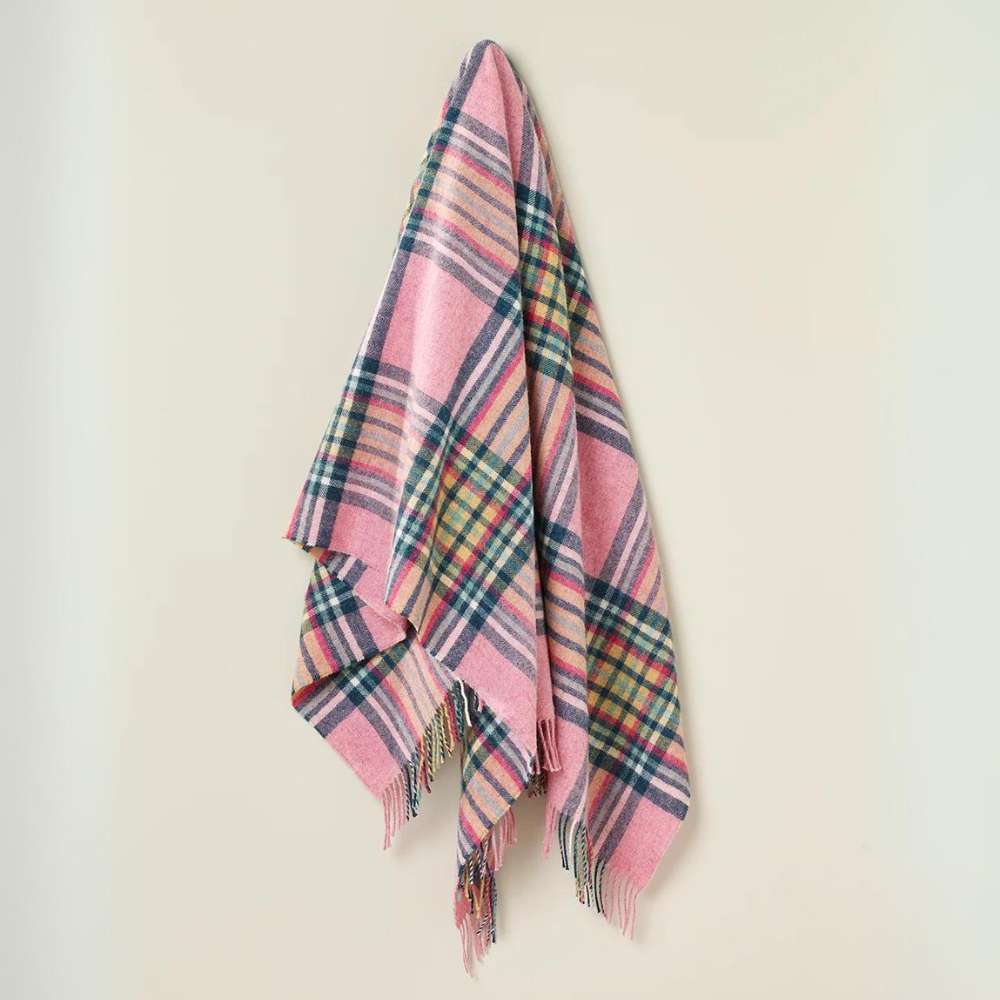 St Ives Pink New Zealand Wool throw is a tartan style throw in light pink with fuchsia, navy and yellow - hanging on a hook