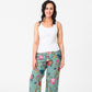 Tree of Life pattern with colourful flowers and foliage on a pale aqua background on pj pants worn by dark haired model with a white tank top