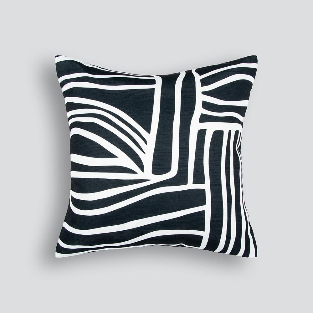 The Maze cushion is black with hand drawn squiggly lines in white